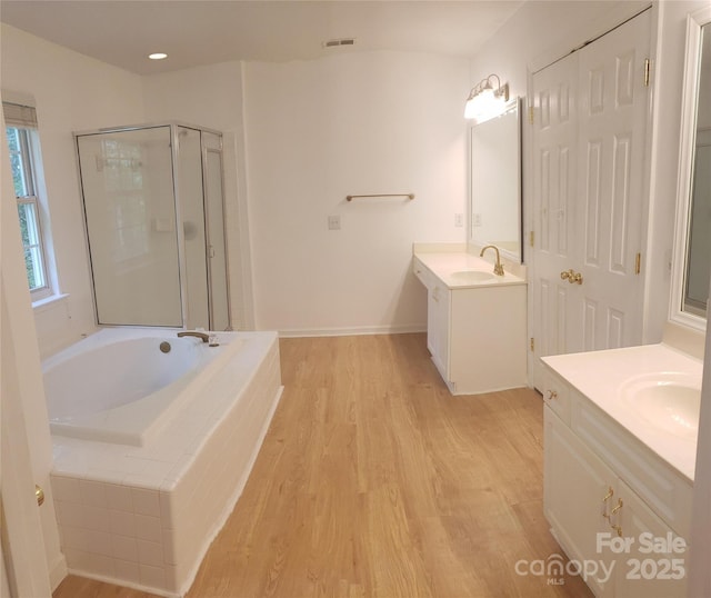 12314 Chickasaw Dr, Huntersville, NC 28078 - full bath with two vanities, a bath, a shower stall, and wood finished floors