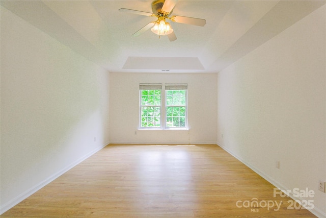 12314 Chickasaw Dr, Huntersville, NC 28078 - empty room featuring a raised ceiling, light wood-style flooring, baseboards, and ceiling fan