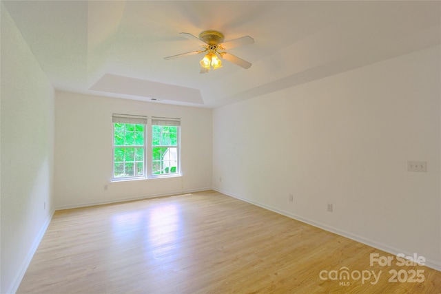 12314 Chickasaw Dr, Huntersville, NC 28078 - spare room with light wood-style floors, a tray ceiling, a ceiling fan, and baseboards