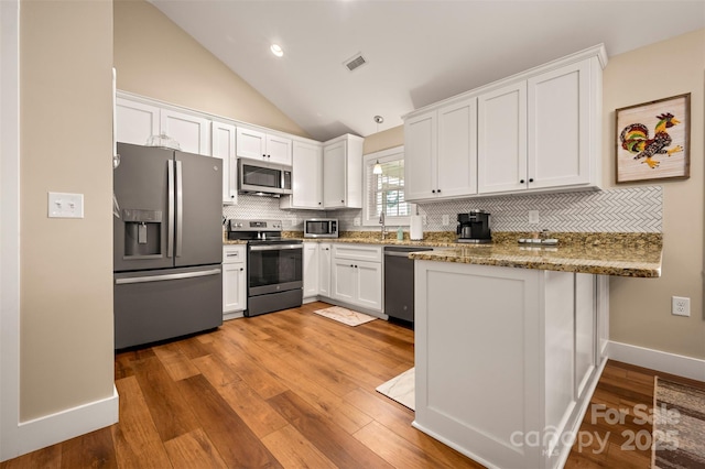 105 Kingston Pl, Spindale, NC 28160 - kitchen with stainless steel appliances, a peninsula, white cabinets, decorative backsplash, and light wood-style floors