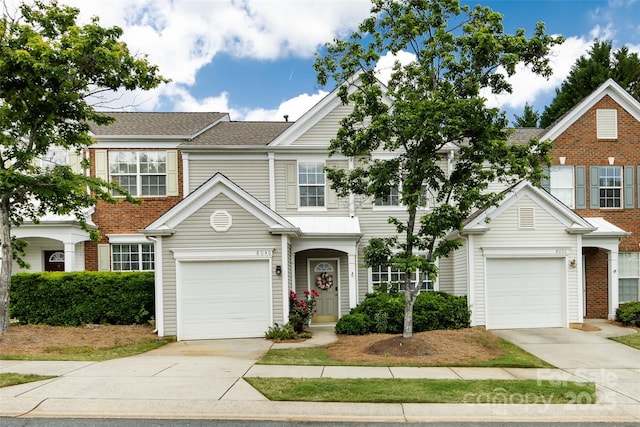 view of front of home featuring driveway, a garage, and roof with shingles