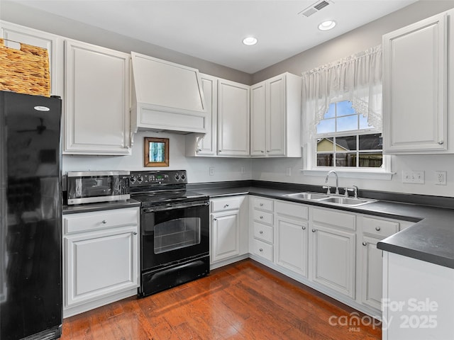 85 Lumber River Rd, Fletcher, NC 28732 - kitchen featuring black appliances, a sink, custom range hood, dark countertops, and dark wood-style floors