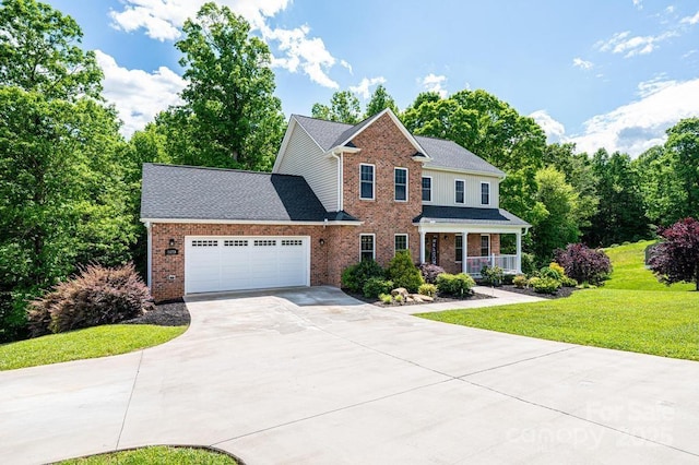 view of front of property featuring driveway, a front lawn, brick siding, a garage, and covered porch