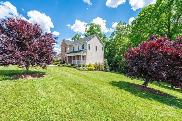 view of green lawn featuring a porch