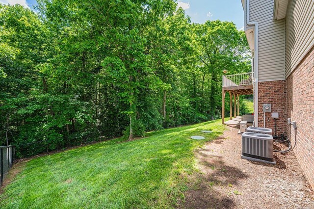 view of yard with central AC unit and a deck