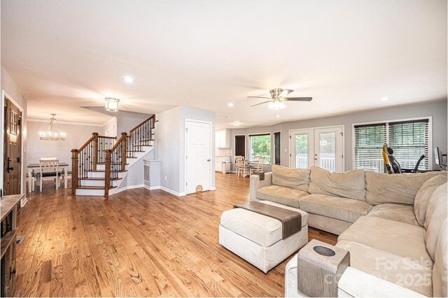 living room featuring stairs, a ceiling fan, recessed lighting, baseboards, and light wood finished floors