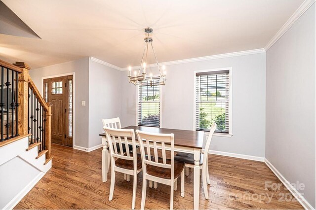 dining space with stairway, wood finished floors, a chandelier, baseboards, and crown molding