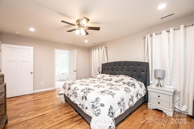 bedroom featuring light wood-style floors, recessed lighting, baseboards, ensuite bathroom, and a ceiling fan