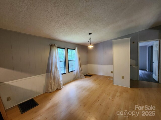 unfurnished room featuring wood finished floors and a textured ceiling