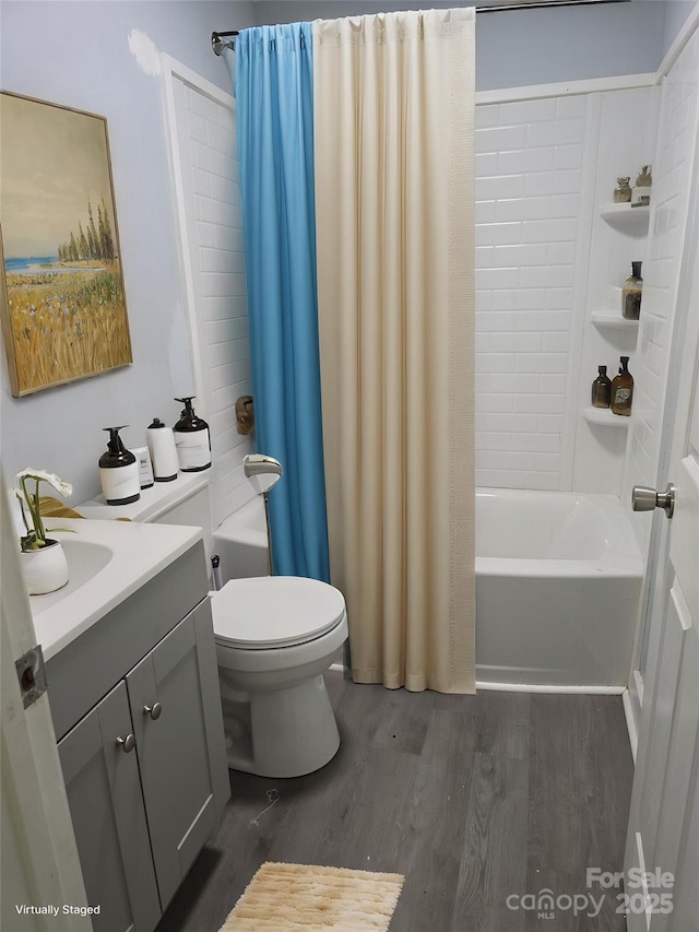 full bath with shower / bath combo, wood finished floors, toilet, and vanity