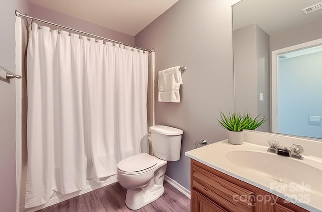 6335 Ziegler Ln, Charlotte, NC 28269 - full bathroom with wood finished floors, toilet, vanity, a shower with curtain, and baseboards