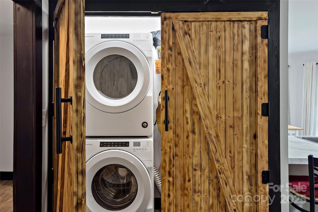 clothes washing area featuring stacked washer and clothes dryer