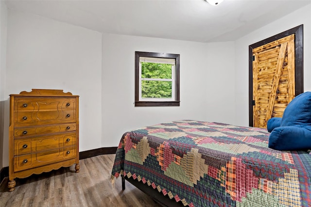 bedroom with wood finished floors and baseboards
