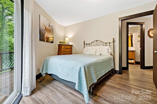 bedroom with wood finished floors and baseboards