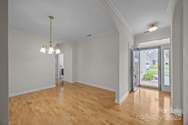 301 Garner Dr, Salisbury, NC 28146 - entrance foyer featuring arched walkways, a chandelier, crown molding, light wood-style flooring, and baseboards