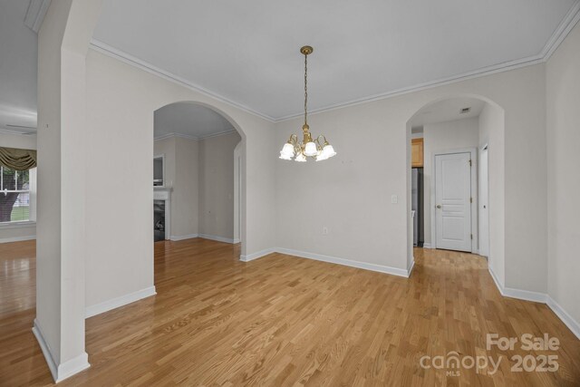 301 Garner Dr, Salisbury, NC 28146 - unfurnished dining area with light wood-type flooring, baseboards, crown molding, a fireplace, and a chandelier