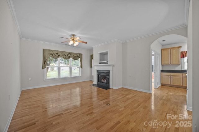 301 Garner Dr, Salisbury, NC 28146 - unfurnished living room with ceiling fan, arched walkways, ornamental molding, light wood-style flooring, and a fireplace with flush hearth