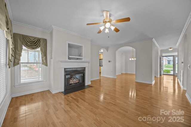 301 Garner Dr, Salisbury, NC 28146 - unfurnished living room featuring arched walkways, a fireplace with flush hearth, ceiling fan, light wood-style flooring, and baseboards
