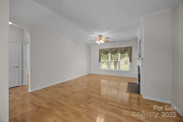 301 Garner Dr, Salisbury, NC 28146 - unfurnished living room featuring arched walkways, a ceiling fan, ornamental molding, a fireplace, and light wood-style flooring