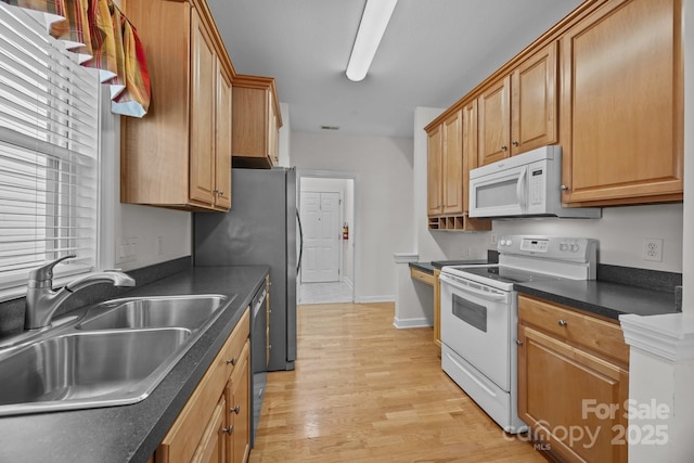 301 Garner Dr, Salisbury, NC 28146 - kitchen with white appliances, a sink, dark countertops, light wood-style floors, and baseboards