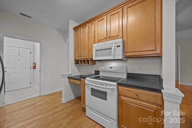 301 Garner Dr, Salisbury, NC 28146 - kitchen featuring white appliances, dark countertops, light wood-type flooring, and baseboards