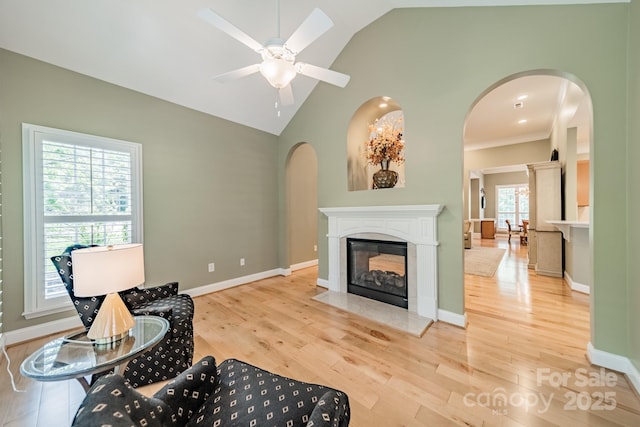 12039 Lawings Corner Dr, Huntersville, NC 28078 - living area with arched walkways, vaulted ceiling, wood finished floors, a ceiling fan, and a multi sided fireplace
