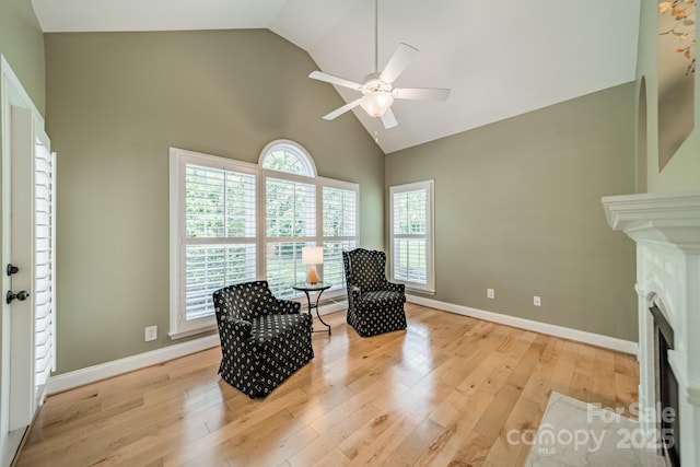 12039 Lawings Corner Dr, Huntersville, NC 28078 - living area featuring high vaulted ceiling, ceiling fan, a fireplace with flush hearth, light wood-style flooring, and baseboards