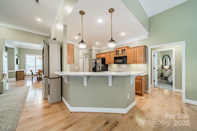 12039 Lawings Corner Dr, Huntersville, NC 28078 - kitchen featuring black microwave, a breakfast bar, refrigerator with ice dispenser, light countertops, and ornamental molding