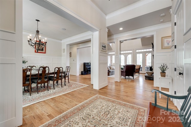 18311 Rosapenny Rd, Charlotte, NC 28278 - foyer with a decorative wall, ornamental molding, light wood-style flooring, a chandelier, and wainscoting