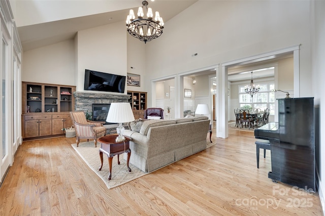 18311 Rosapenny Rd, Charlotte, NC 28278 - living room featuring a chandelier, high vaulted ceiling, light wood-style flooring, and a fireplace
