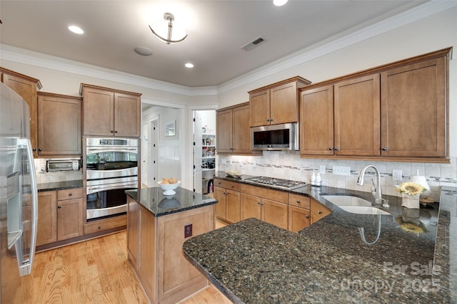 18311 Rosapenny Rd, Charlotte, NC 28278 - kitchen featuring a sink, stainless steel appliances, dark stone counters, crown molding, and light wood-type flooring