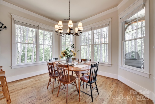 18311 Rosapenny Rd, Charlotte, NC 28278 - dining room with healthy amount of natural light, a chandelier, baseboards, wood finished floors, and crown molding
