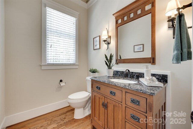 18311 Rosapenny Rd, Charlotte, NC 28278 - half bath with vanity, toilet, wood finished floors, plenty of natural light, and ornamental molding
