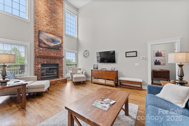 230 Fairway Falls Rd, Mills River, NC 28759 - living room with a towering ceiling, a brick fireplace, wood finished floors, and baseboards