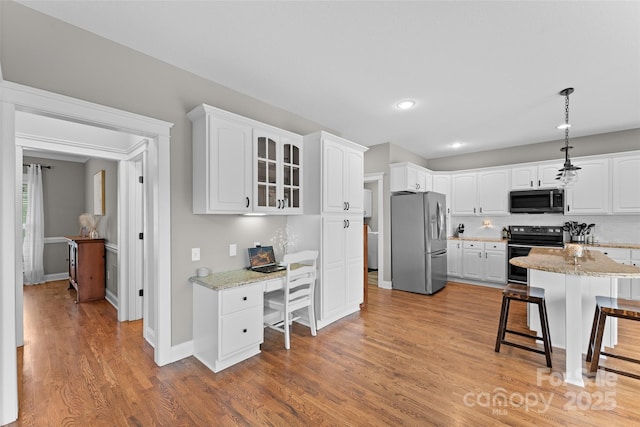 230 Fairway Falls Rd, Mills River, NC 28759 - kitchen with stainless steel refrigerator with ice dispenser, black range with electric stovetop, a breakfast bar, light wood-style flooring, and white cabinets