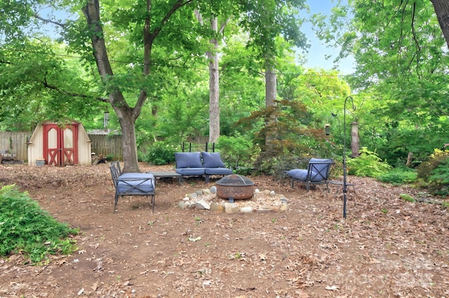 3430 Rea Rd, Charlotte, NC 28226 - view of yard with an outdoor fire pit, a storage unit, an outdoor structure, and fence
