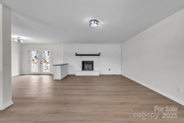 276 Bob Mcneill Rd, West Jefferson, NC 28694 - unfurnished living room with french doors, a fireplace, wood finished floors, and baseboards