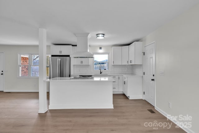 276 Bob Mcneill Rd, West Jefferson, NC 28694 - kitchen featuring island exhaust hood, a sink, freestanding refrigerator, a center island, and backsplash