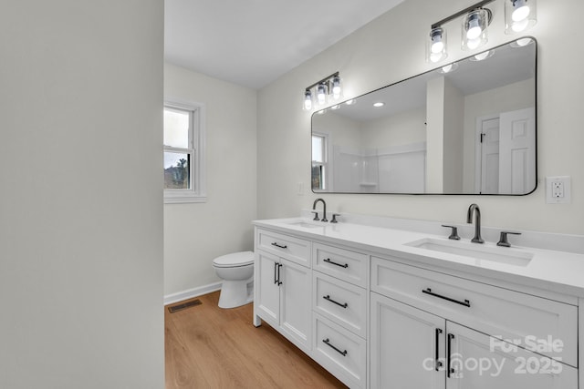 276 Bob Mcneill Rd, West Jefferson, NC 28694 - full bathroom featuring wood finished floors, baseboards, double vanity, and toilet