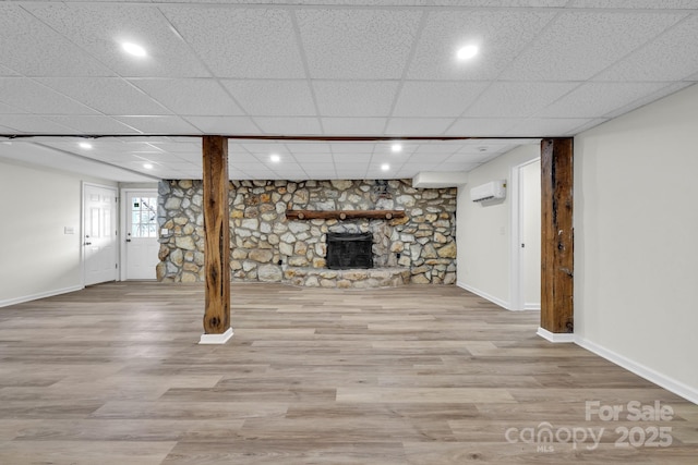 276 Bob Mcneill Rd, West Jefferson, NC 28694 - below grade area with a fireplace, a wall mounted air conditioner, baseboards, wood finished floors, and a paneled ceiling
