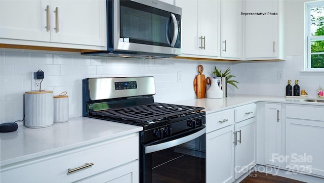 6612 Barcelona Way, Charlotte, NC 28214 - kitchen featuring appliances with stainless steel finishes, decorative backsplash, light countertops, and white cabinetry