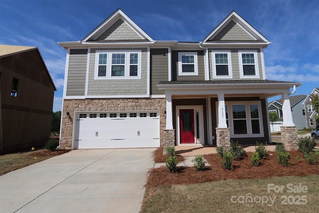 craftsman-style home featuring covered porch, driveway, an attached garage, and stone siding