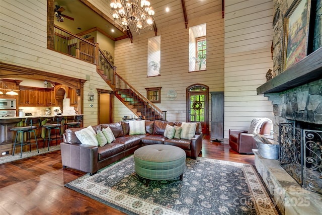414 Trails End Rd, Bryson City, NC 28713 - living room with high vaulted ceiling, wooden walls, a stone fireplace, stairs, and wood finished floors