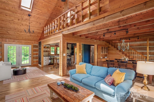 225 Ford Rd, Waynesville, NC 28786 - living room with wood walls, wood finished floors, a skylight, wooden ceiling, and a chandelier