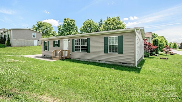 back of house featuring crawl space and a lawn