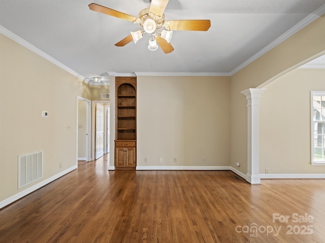unfurnished living room featuring wood finished floors, ornamental molding, baseboards, ceiling fan, and decorative columns