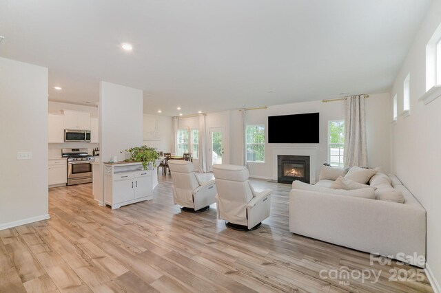 18026 Stark Way, Charlotte, NC 28278 - living room with light wood finished floors, a glass covered fireplace, and recessed lighting