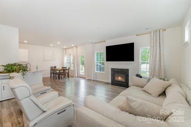 18026 Stark Way, Charlotte, NC 28278 - living room featuring light wood-style flooring, recessed lighting, a fireplace with flush hearth, and baseboards
