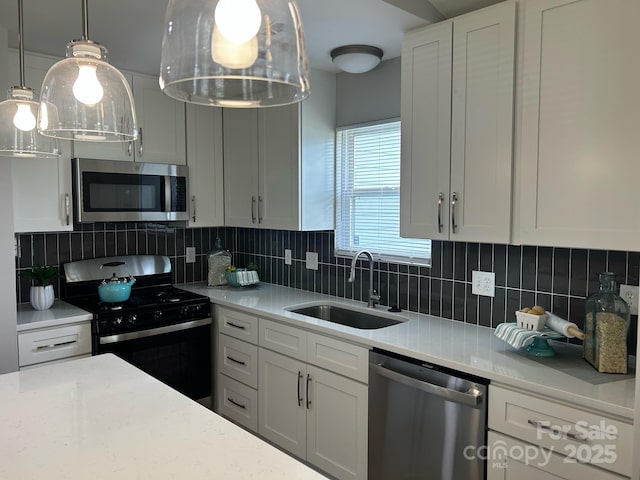 1004 Johnson St, Charlotte, NC 28206 - kitchen with stainless steel appliances, a sink, decorative backsplash, and white cabinetry