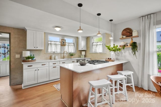 1000 Oakshade Ave, Kannapolis, NC 28083 - kitchen featuring a sink, a kitchen bar, light wood-style floors, and white cabinetry
